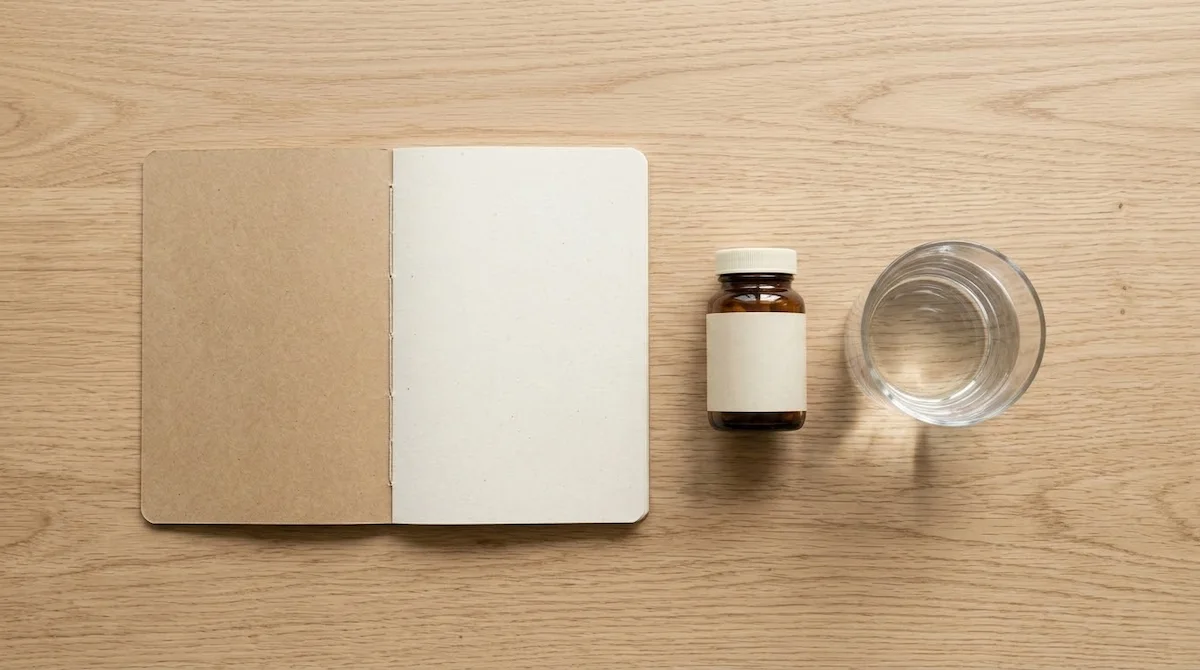 notebook and supplement beside a glass of water — deciding whether magnesium glycinate helps sleep