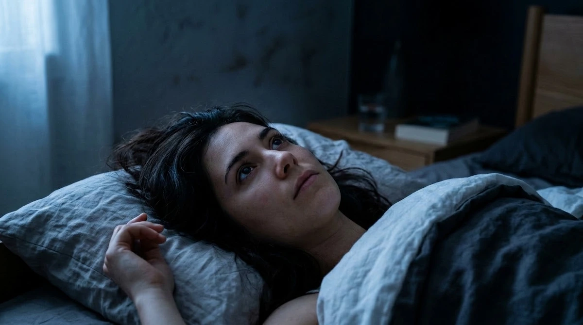 person lying awake at night — poor sleep is a common low magnesium symptom